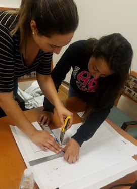 student measuring to create cardboard phone stand